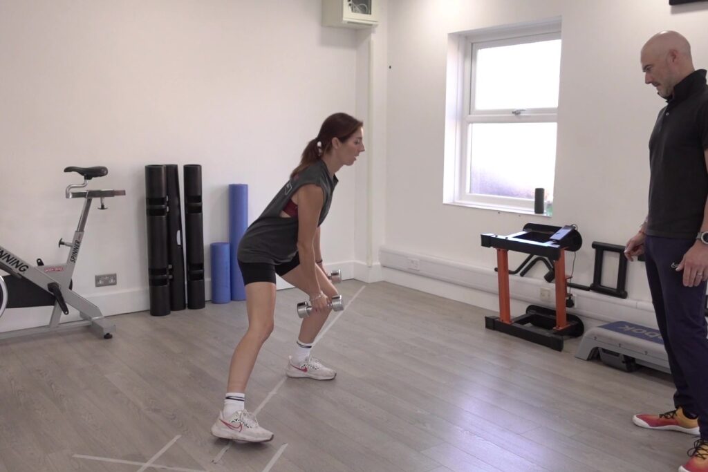 Dom Meacher watching a client do a lateral lunge with dumbbells at Ocean Fitness Poole
